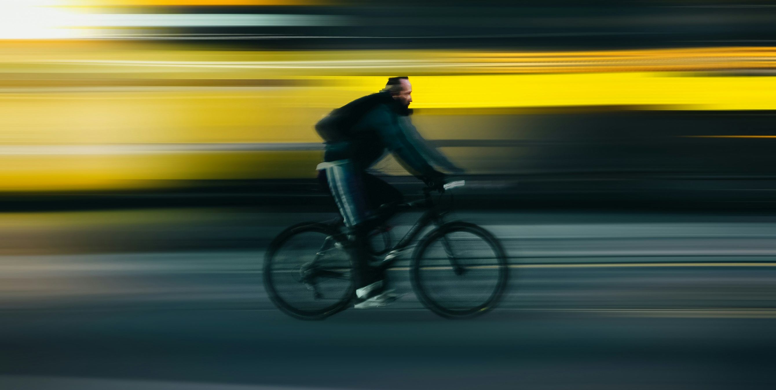 A man on a bike going so fast that the background is just a series of blurred lines.